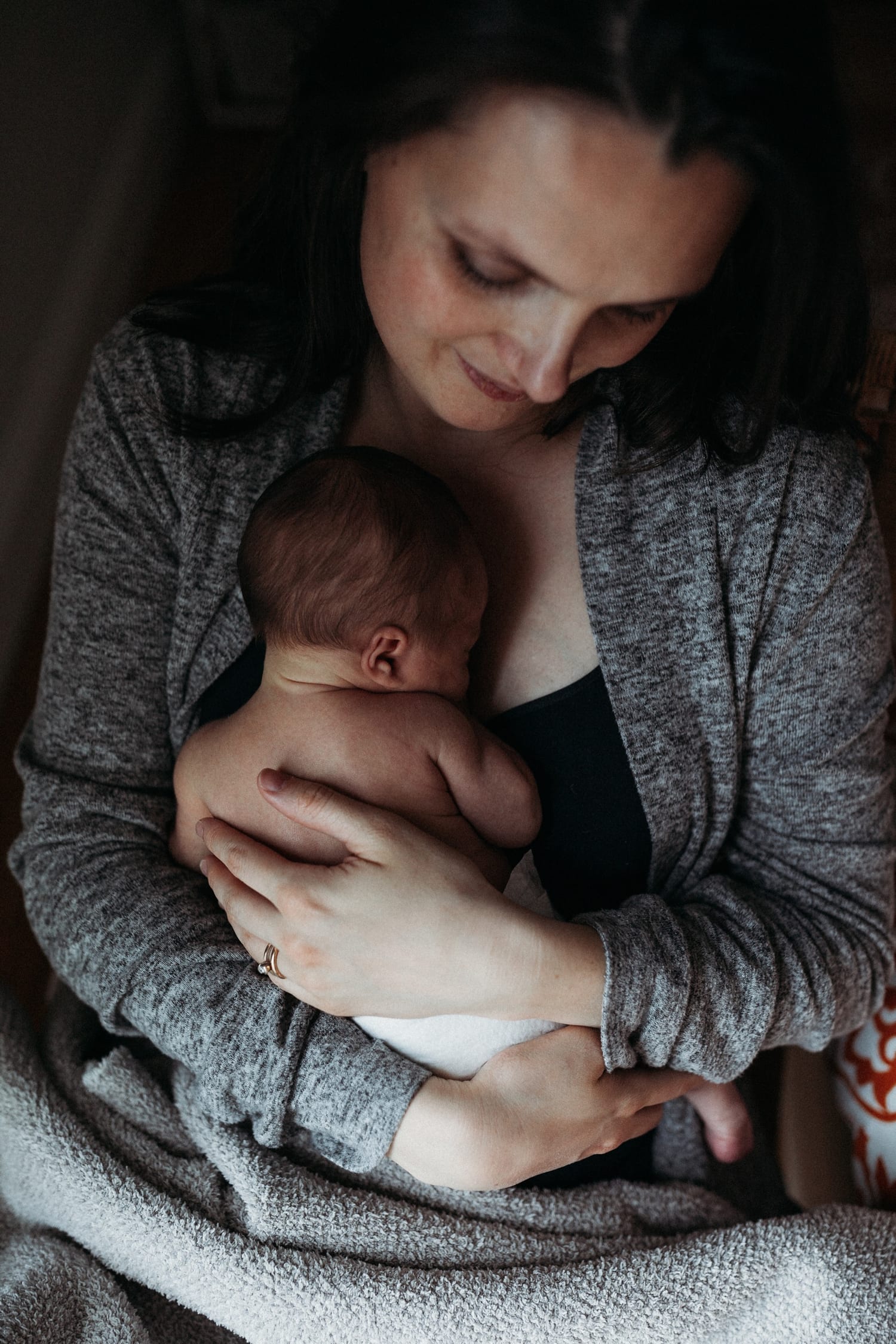 Mom gazes down at her newborn cradled against her chest