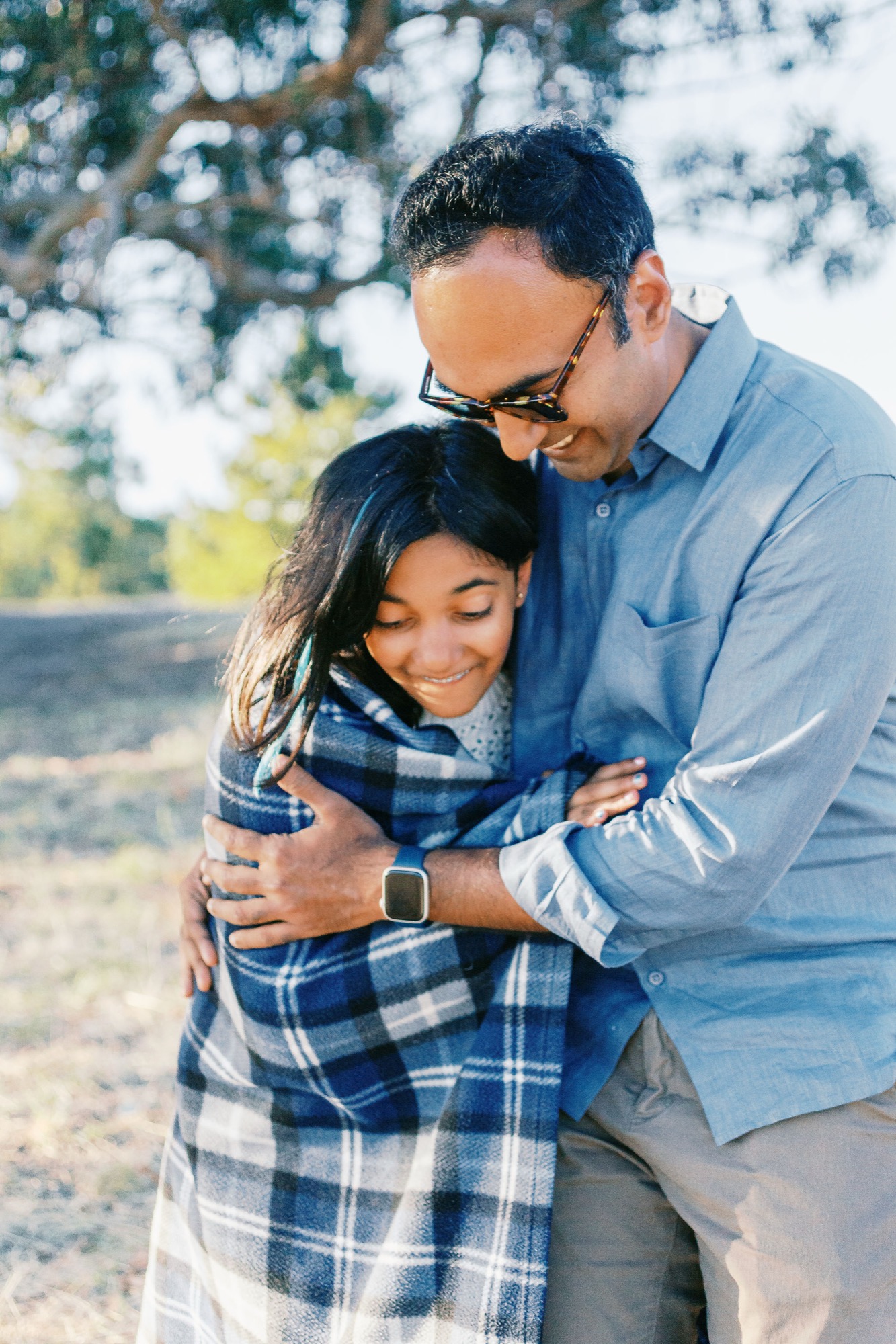 Marin family photographer captures a tender father-daughter embrace in warm golden-hour light during an outdoor family session in Marin County — a quiet, joyful moment of connection that perfectly embodies lifestyle family photography at its most authentic.