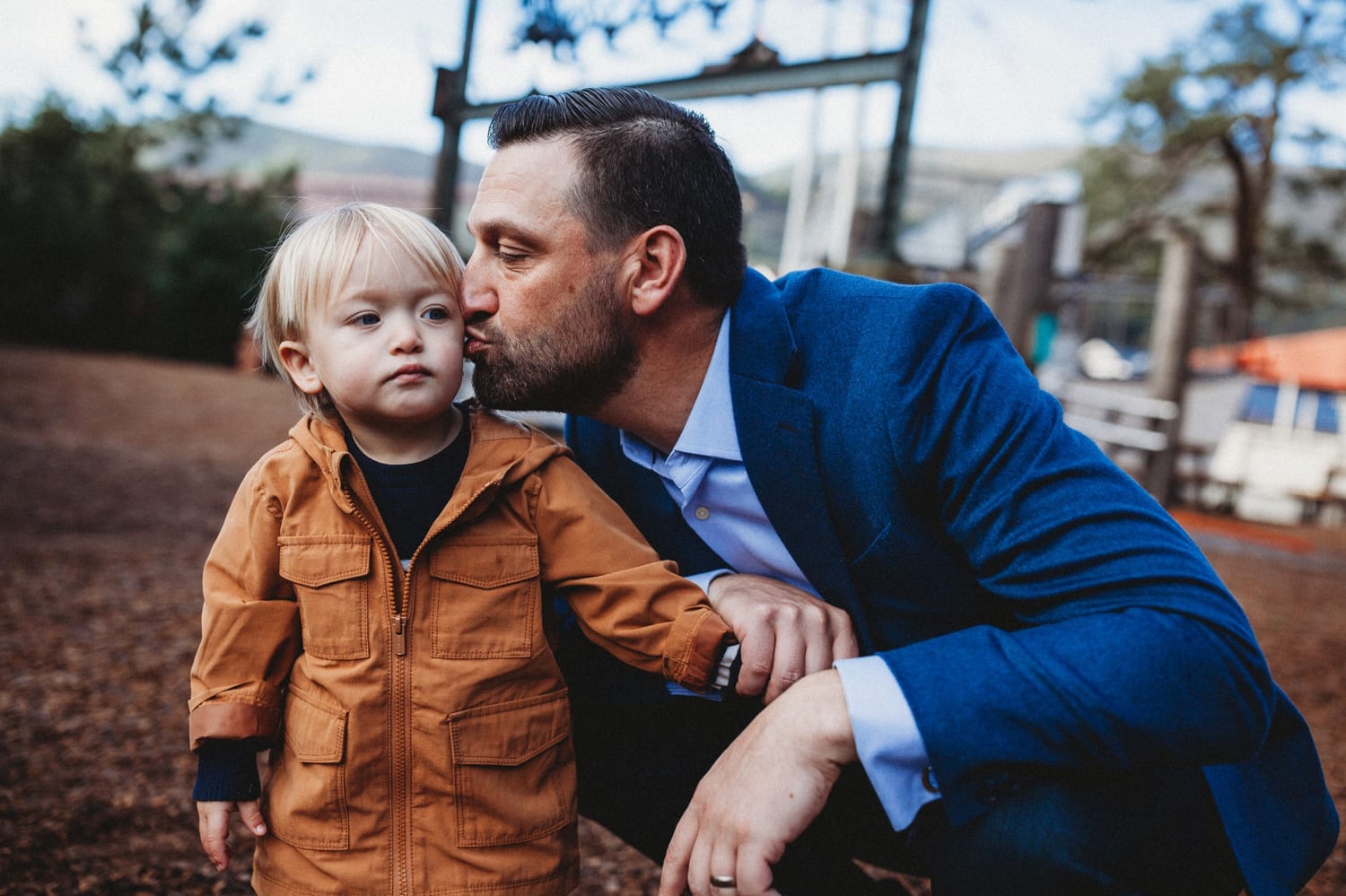 Family walks along the waterfront, toddler on dad's shoulders, Golden Gate Bridge behind