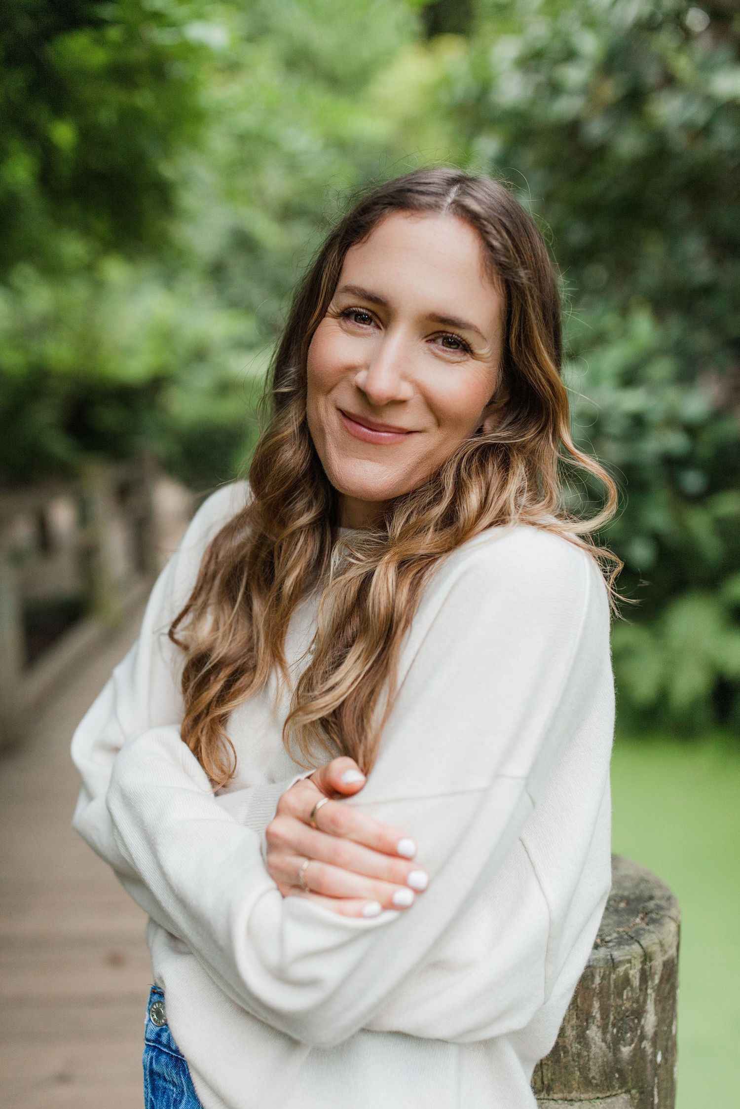 Natural outdoor headshot on a wooden bridge surrounded by lush green foliage — Marin County