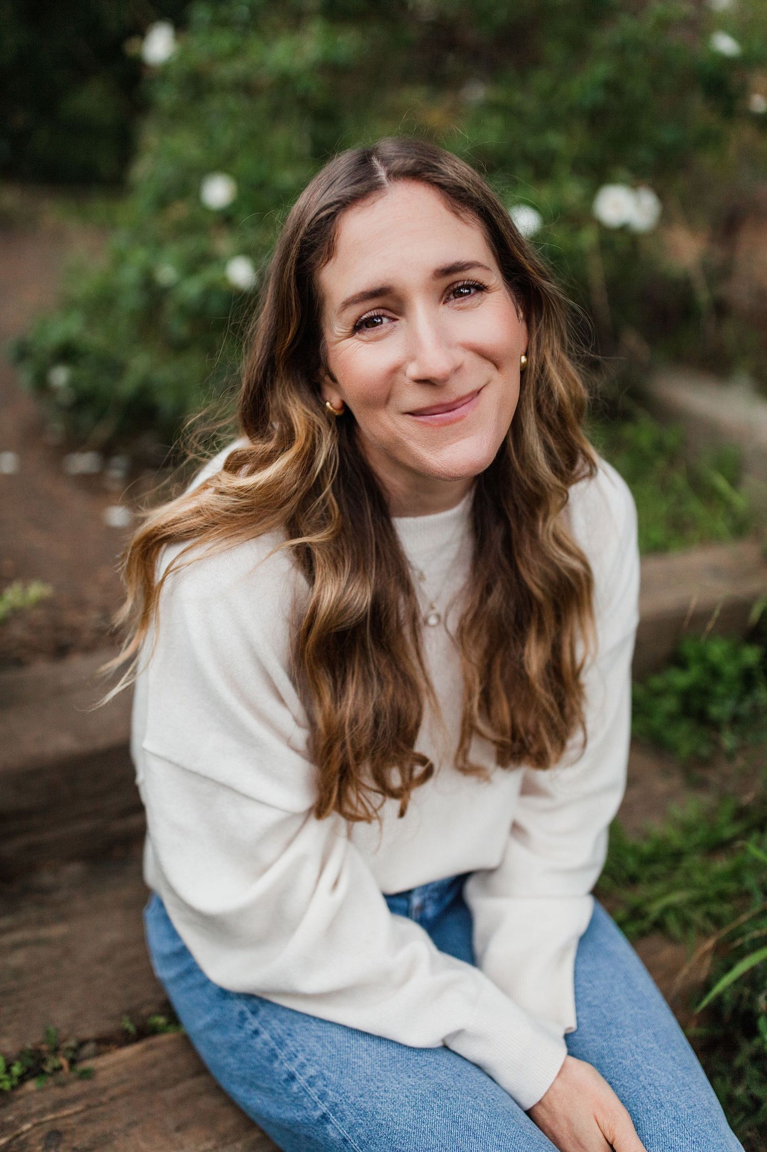 Natural headshot portrait sitting on a log in a garden setting — Marin County