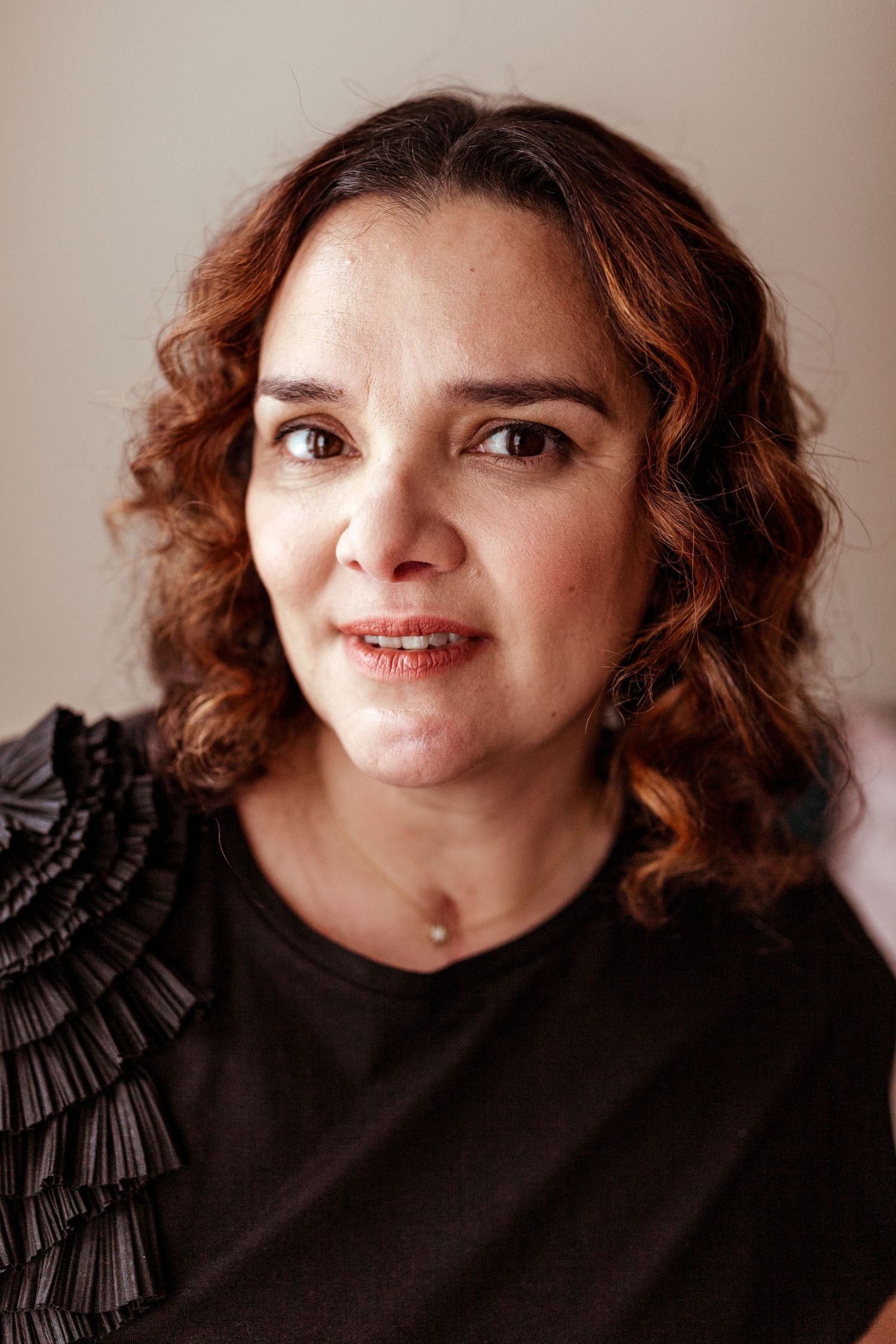 Natural portrait with curly brown hair in a black top — outdoor headshot