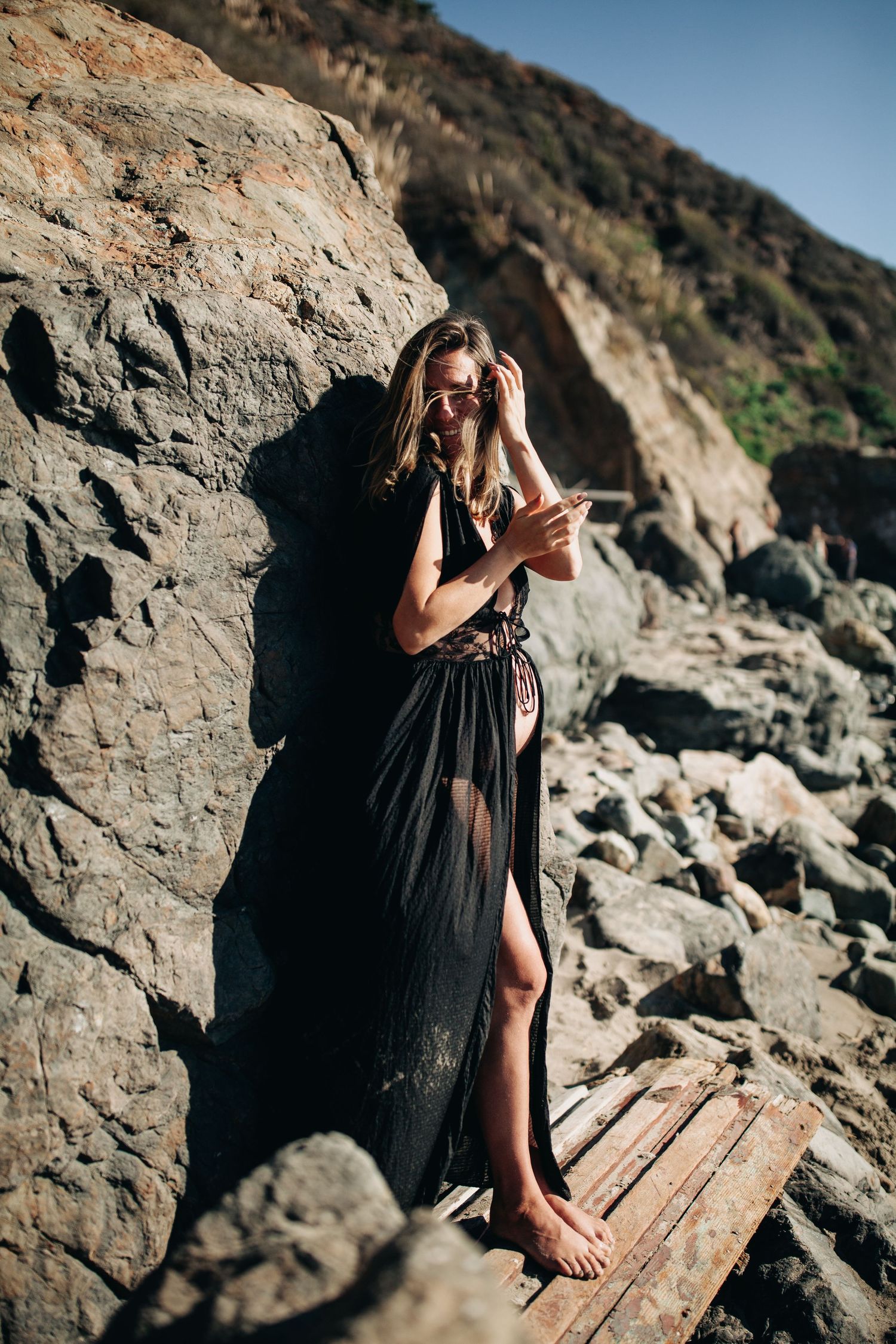 Pregnant woman in a flowing black dress at golden hour — dramatic maternity portrait in Marin County