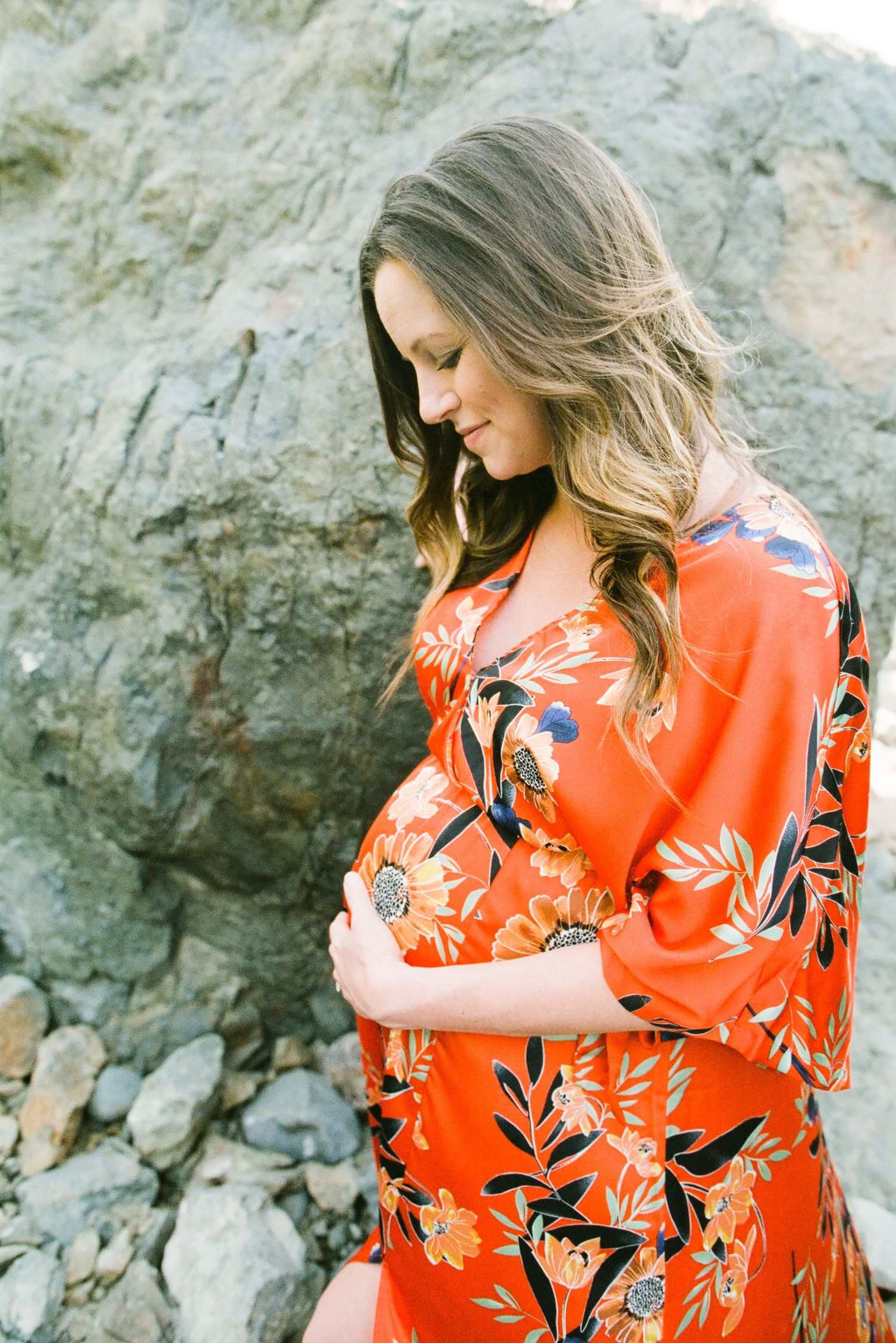 Woman in a vibrant orange floral dress — outdoor maternity session in Marin County