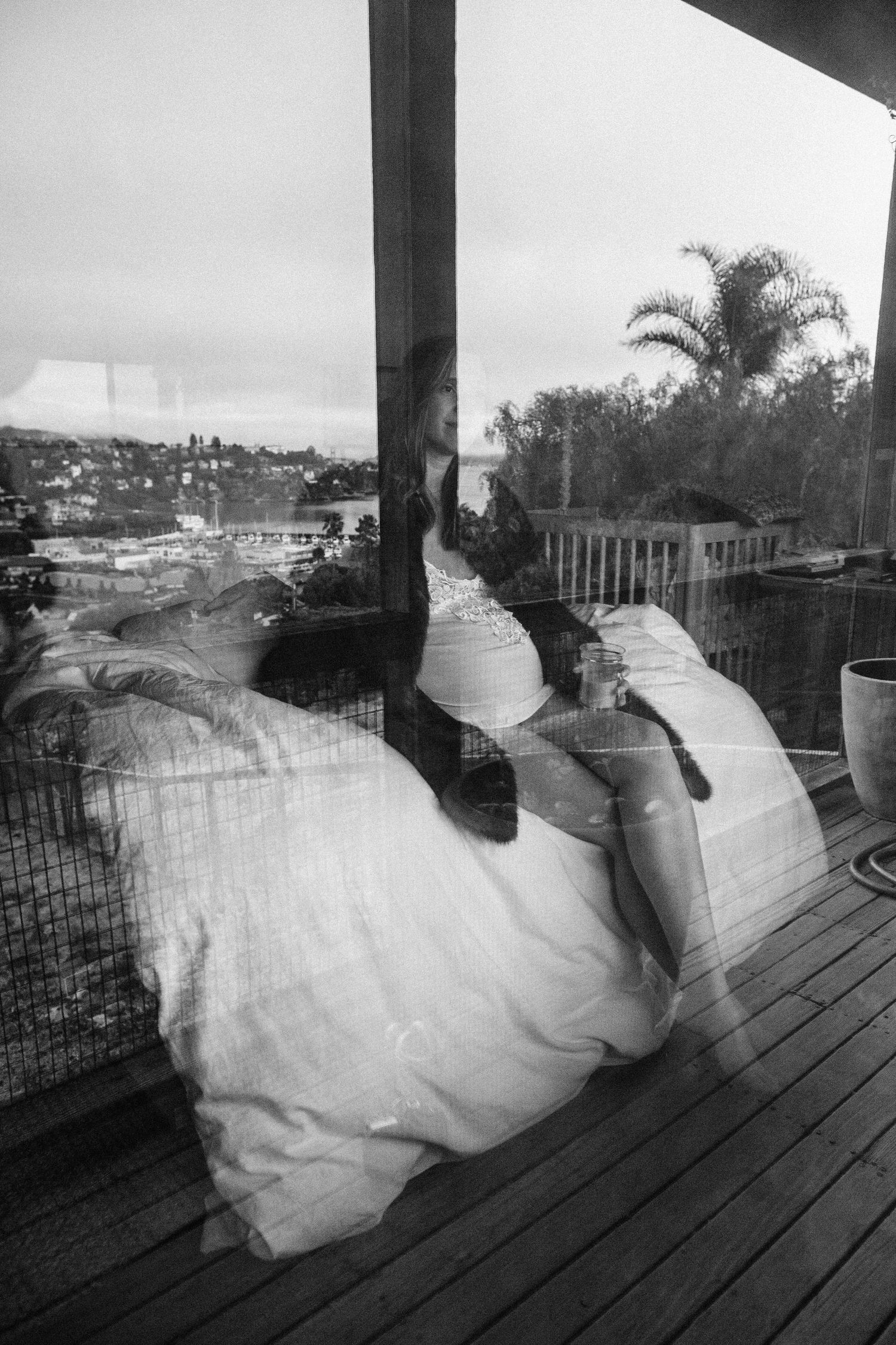 Black and white reflection of a pregnant figure on a deck — maternity photography in Marin County