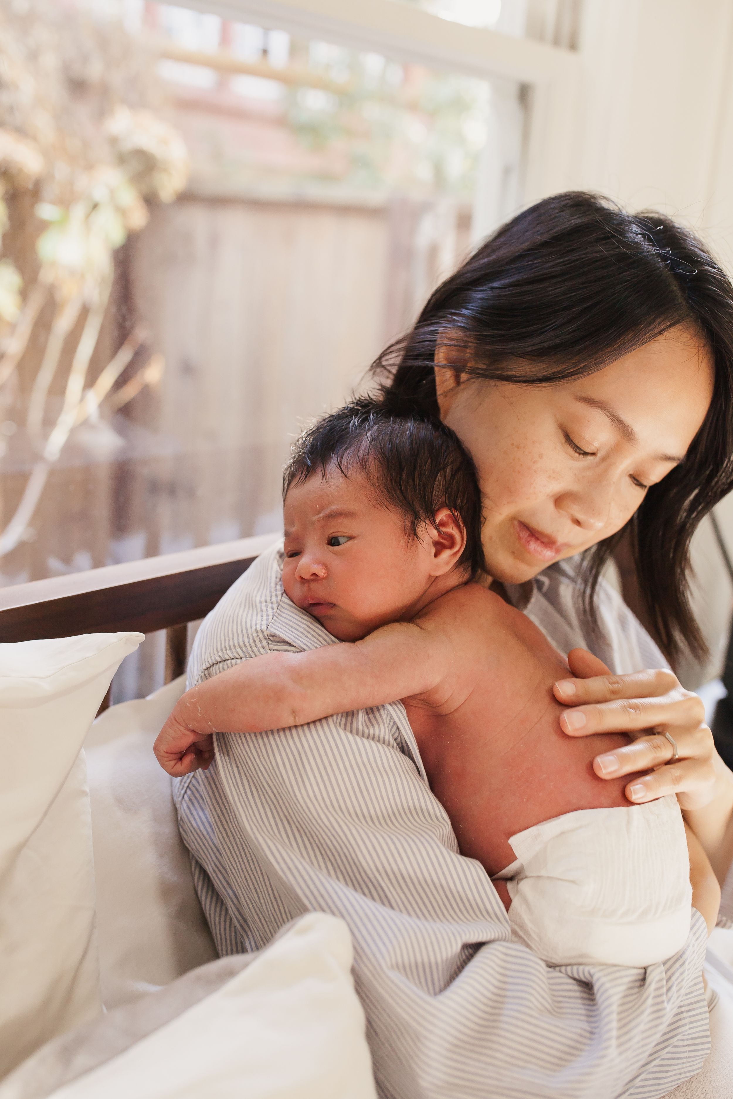 Close-up of hands tenderly holding a tiny newborn baby