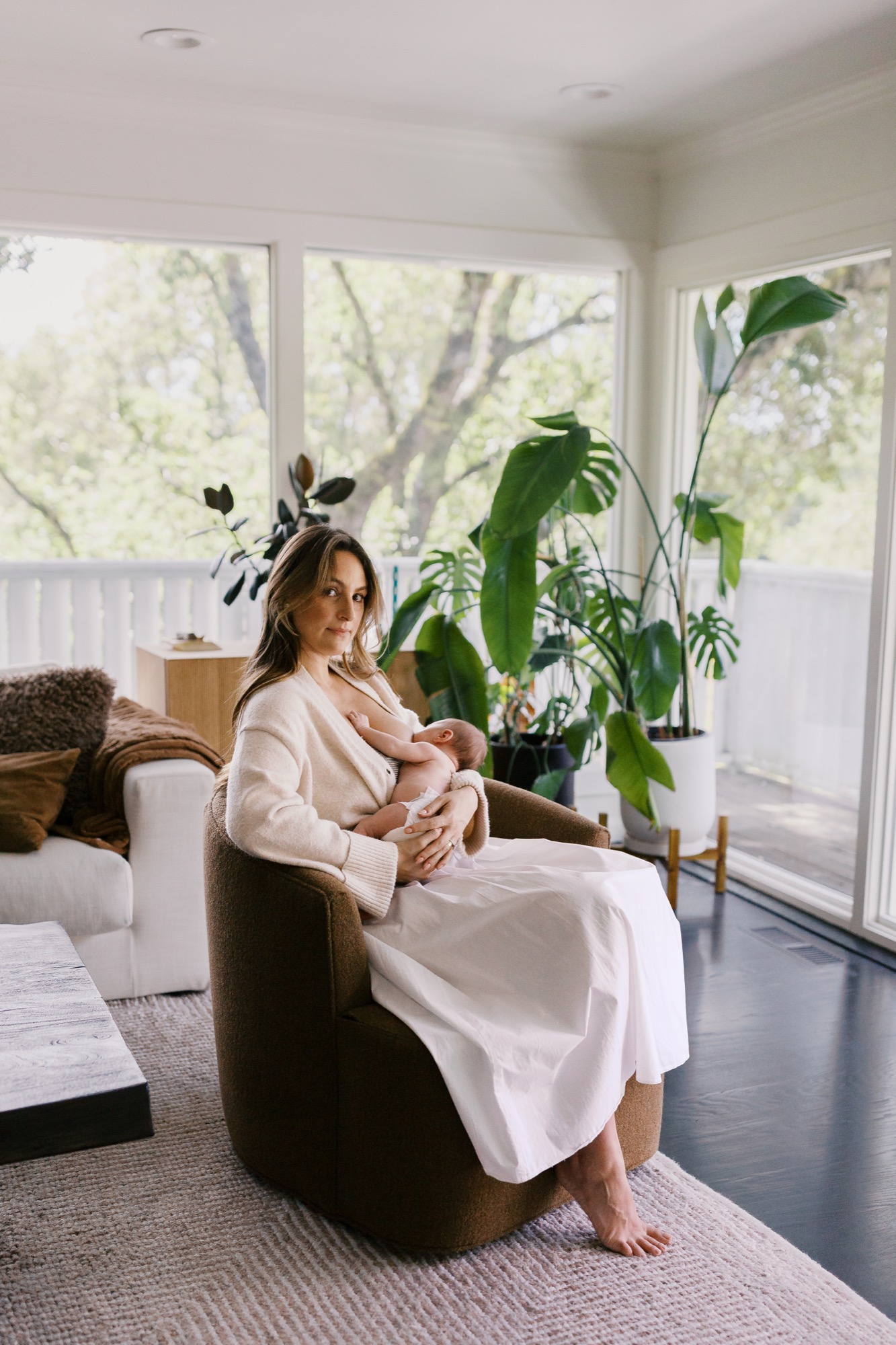 Victoria nurses Gwen in her sun-filled, plant-filled living room