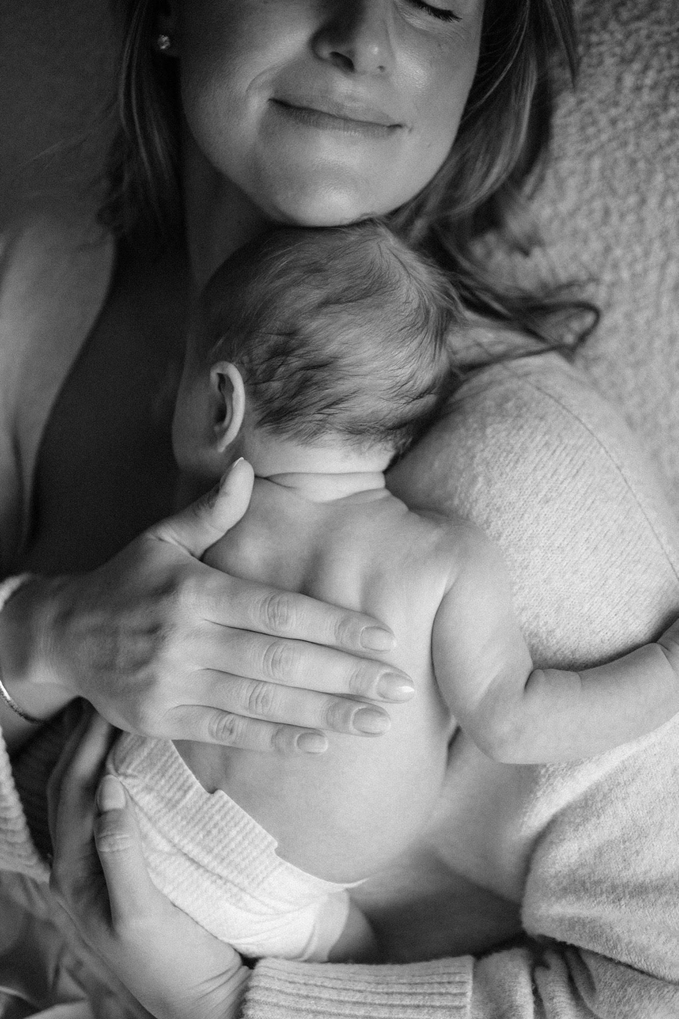 Victoria holds Gwen skin-to-skin, eyes closed, cradling her bare back against her chest