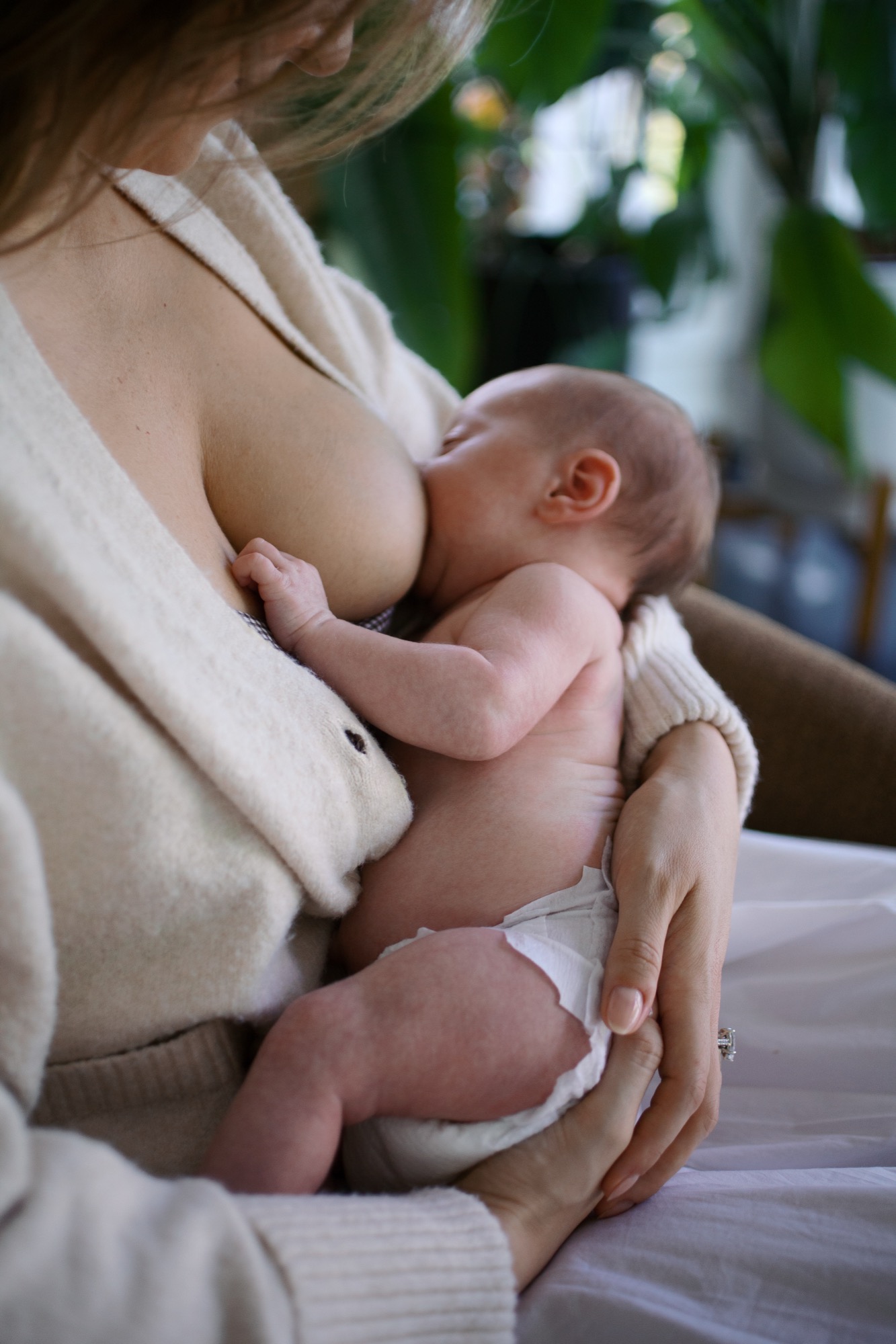 A quiet moment of nourishment and closeness, captured in the soft light of their Marin County home — baby's tiny fist curled against mom, perfectly content and held. This is the kind of image that tells the whole story of those early newborn days without a single word.