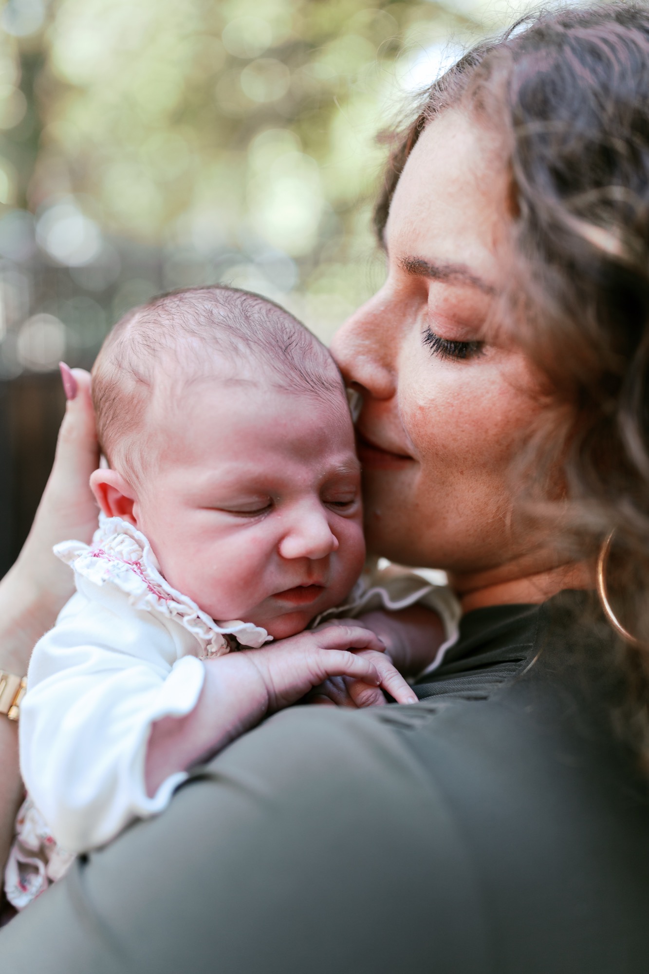 Marin newborn photographer captures a mother tenderly nuzzling her two-week-old daughter in soft dappled light at their Palo Alto home — an intimate lifestyle newborn portrait full of quiet, unguarded love.