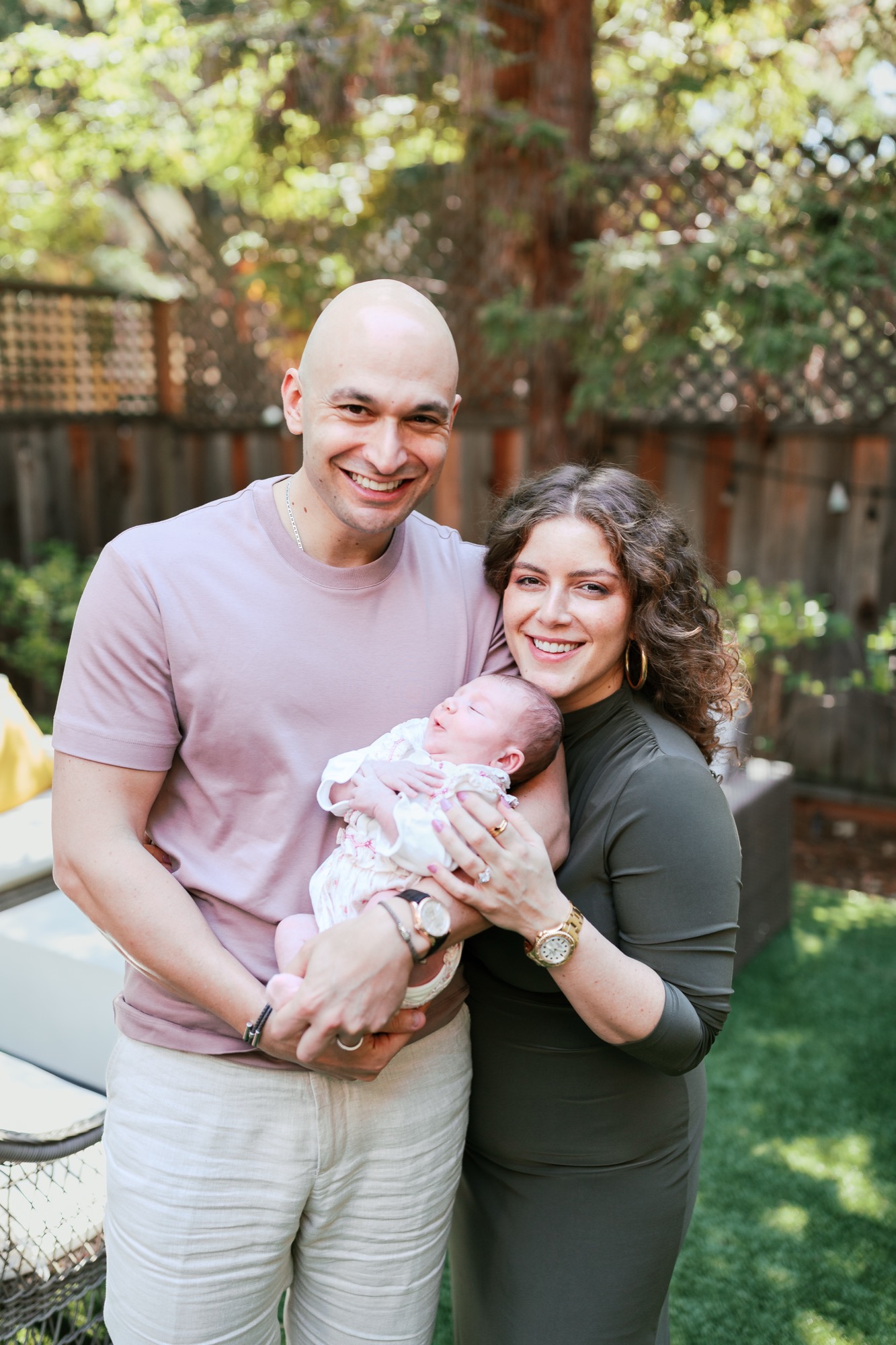 Marin newborn photographer captures a glowing family of three — mom, dad, and their two-week-old baby Dalia — smiling together in the backyard of their Palo Alto home, celebrating the first days of new parenthood.